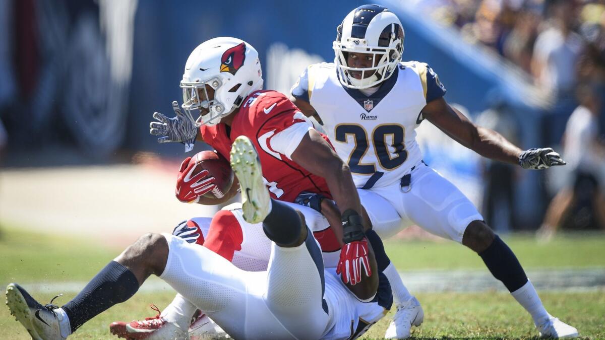 Arizona Cardinals running back David Johnson is tackled by Rams linebacker Cory Littleton (58) and defensive back Lamarcus Joyner (20) during the second quarter at Los Angeles Memorial Coliseum on Sunday.