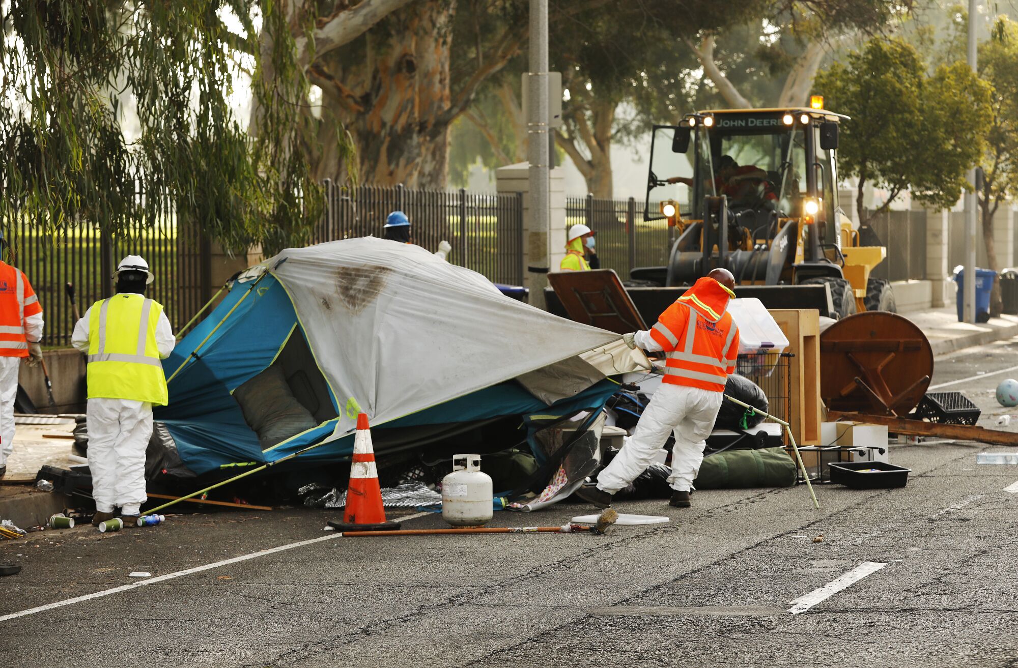 Members of a clean-up crew dismantle tents on the Veterans Row homeless encampment.
