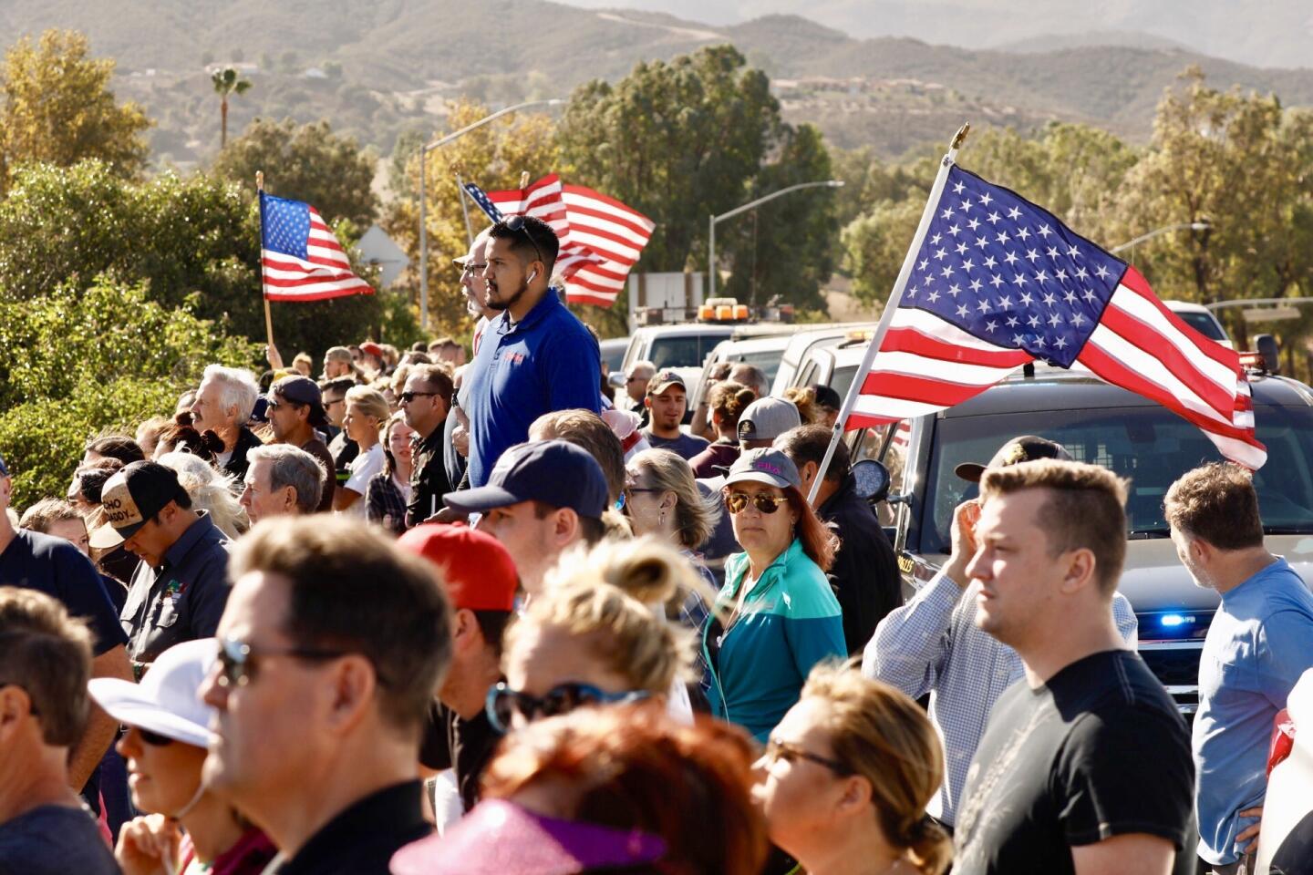 Crowds watch the procession carrying the flag-draped casket of Sgt. Ron Helus to the medical examiner's office in Ventura.