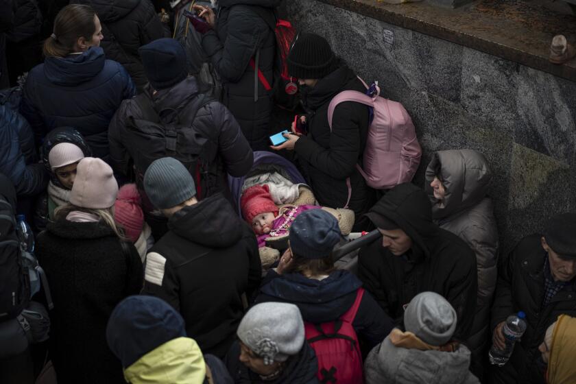 Passengers wait for a train to Poland, inside Lviv railway station, Sunday, Feb. 27, 2022, in Lviv, west Ukraine. 