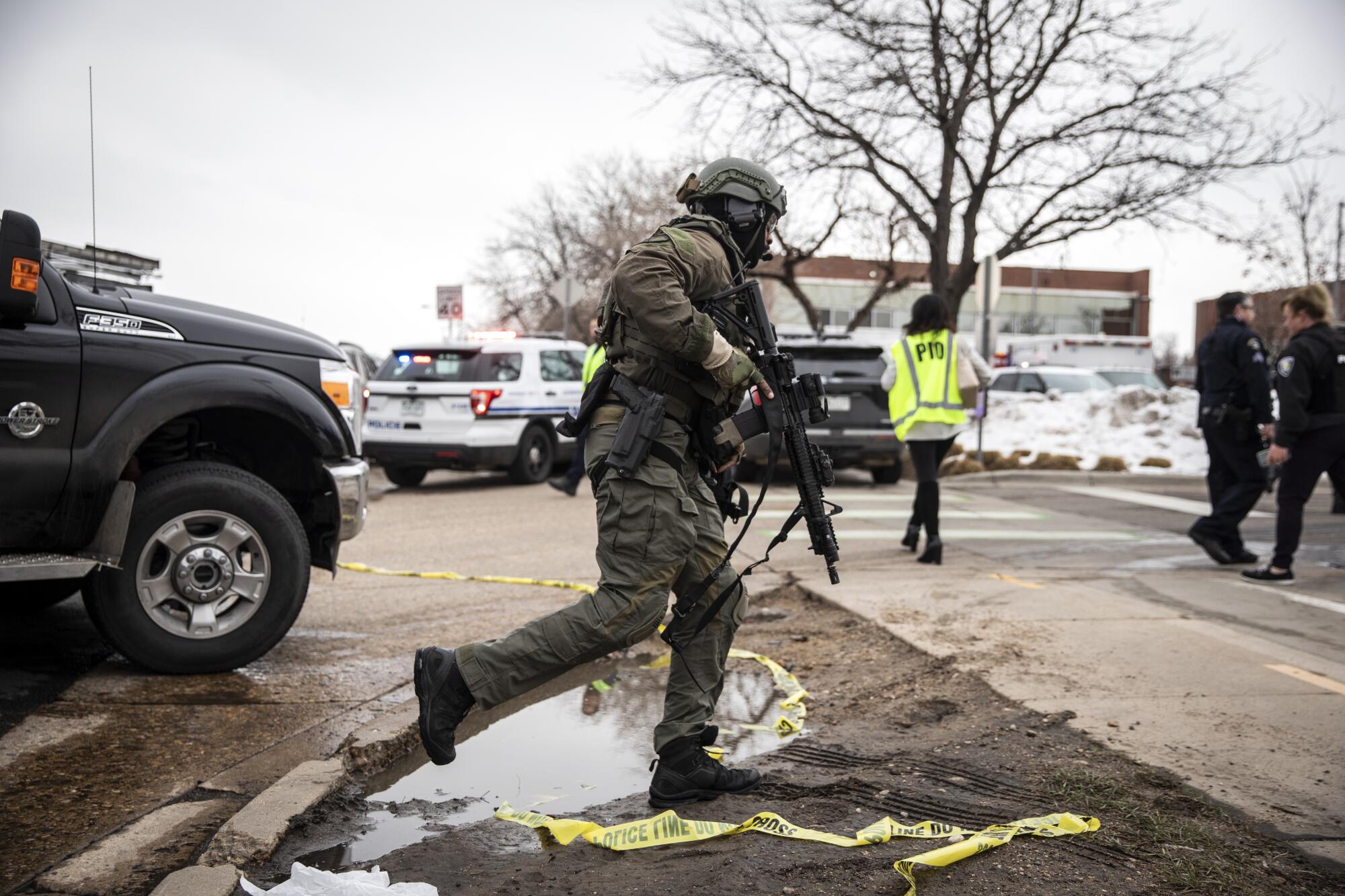 A SWAT team member runs toward a King Soopers grocery store where a gunman opened fire on March 22, 2021 in Boulder