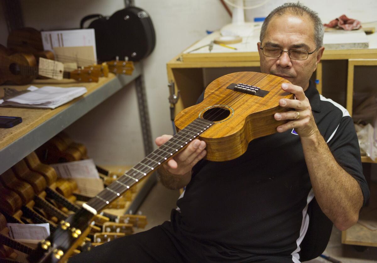 Chris Kamaka fine-tunes a hand-crafted ukulele at Kamaka Ukulele in Honolulu.