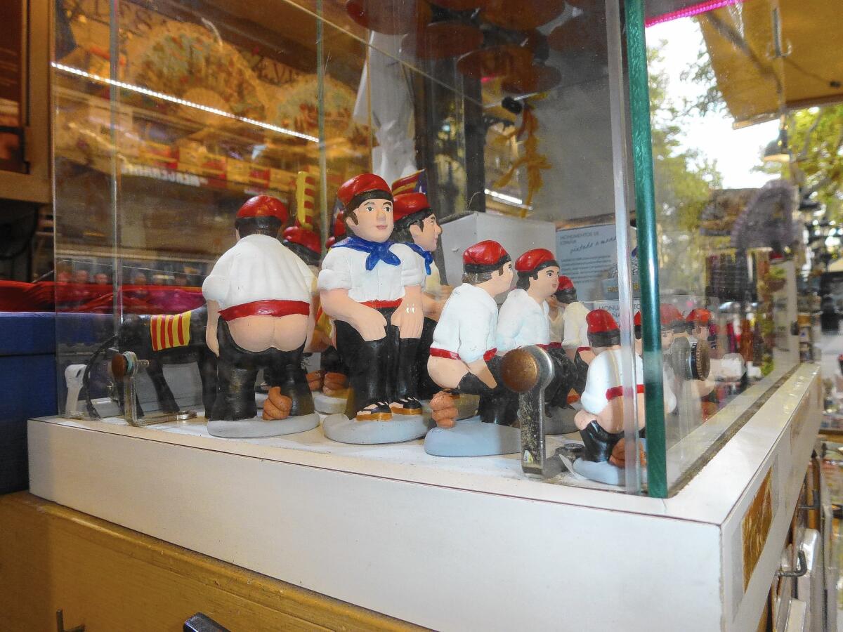 Barcelona's traditional caganer figurines, also called "poopers," are sold at a kiosk. The Catalan folk-art personage, put in creches, is often portrayed as a famous figure.