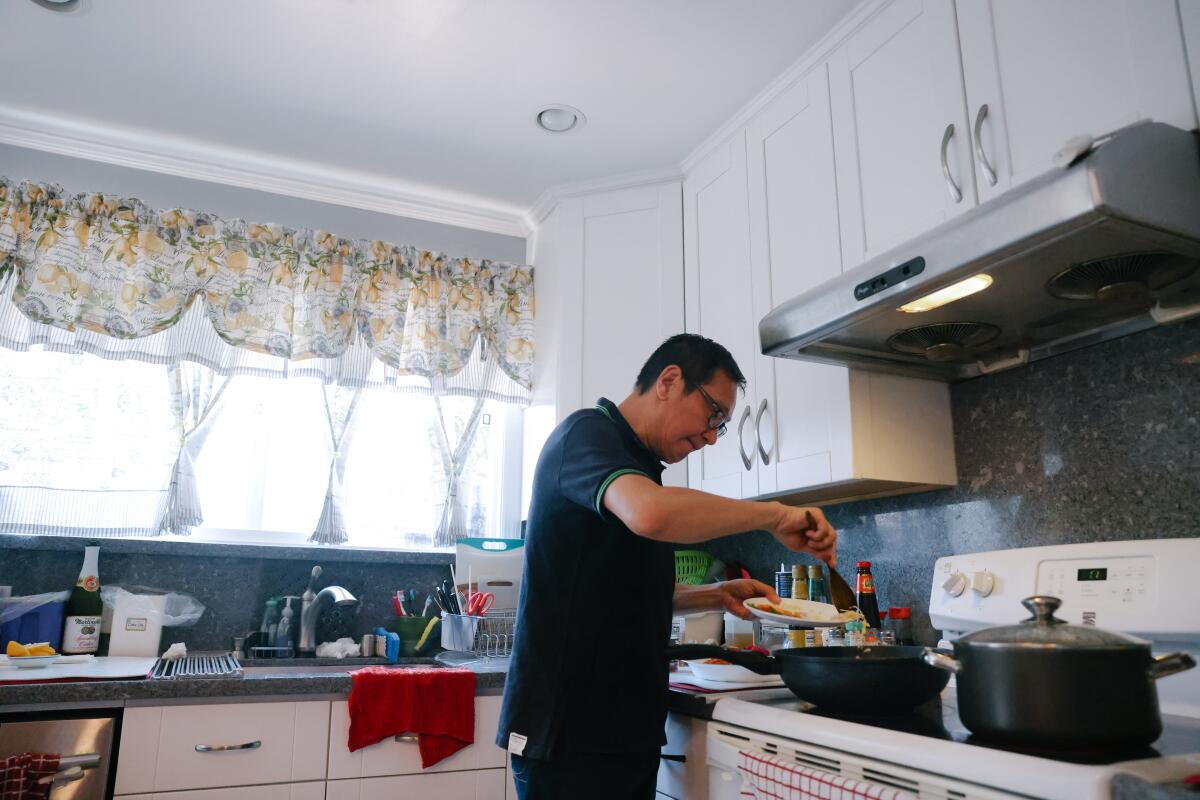 Johnny Wong prepares dinner at his home in San Mateo, Calif.