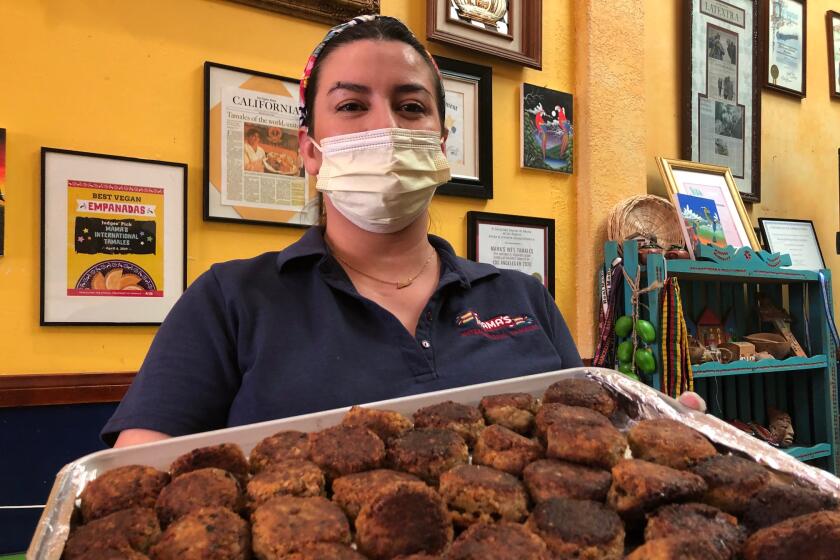 La empresaria Claudia López, originaria de El Salvador, muestra unas albóndigas veganas que recién fueron incluidas en el menú.