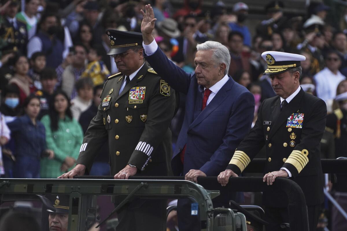 El presidente mexicano Andrés Manuel López Obrador, centro, saluda acompañado de mandatarios militares 
