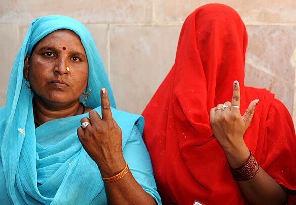 Two women leaving a polling station in Chandigarh, India, show off the ink marks on their fingers signifying that they had voted in national elections. The final phase of India's five-phase general elections is underway.