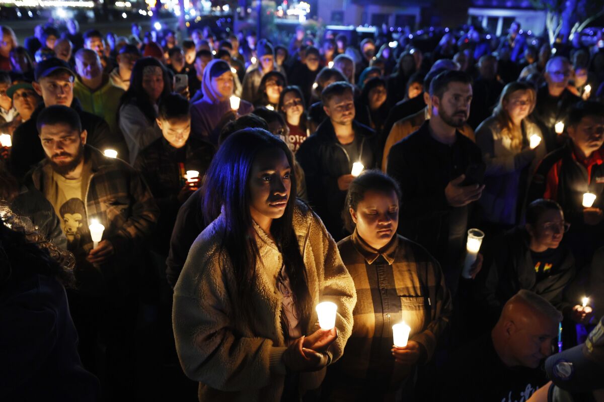 Kayla Mathews, left, and Dawn Freeman attend a candlelight vigil.