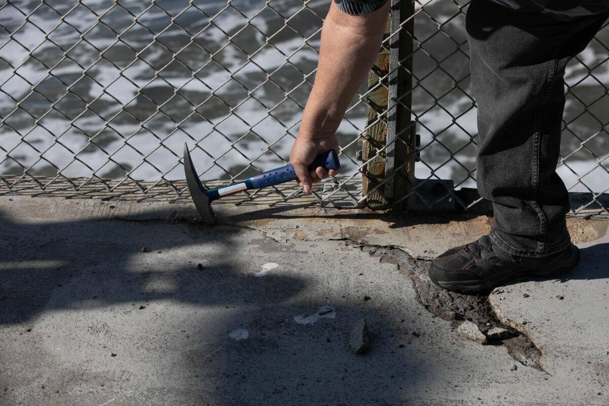 Matthew Martinez, a structural engineer and vice president of Moffatt & Nichol, chips away at the Ocean Beach Pier