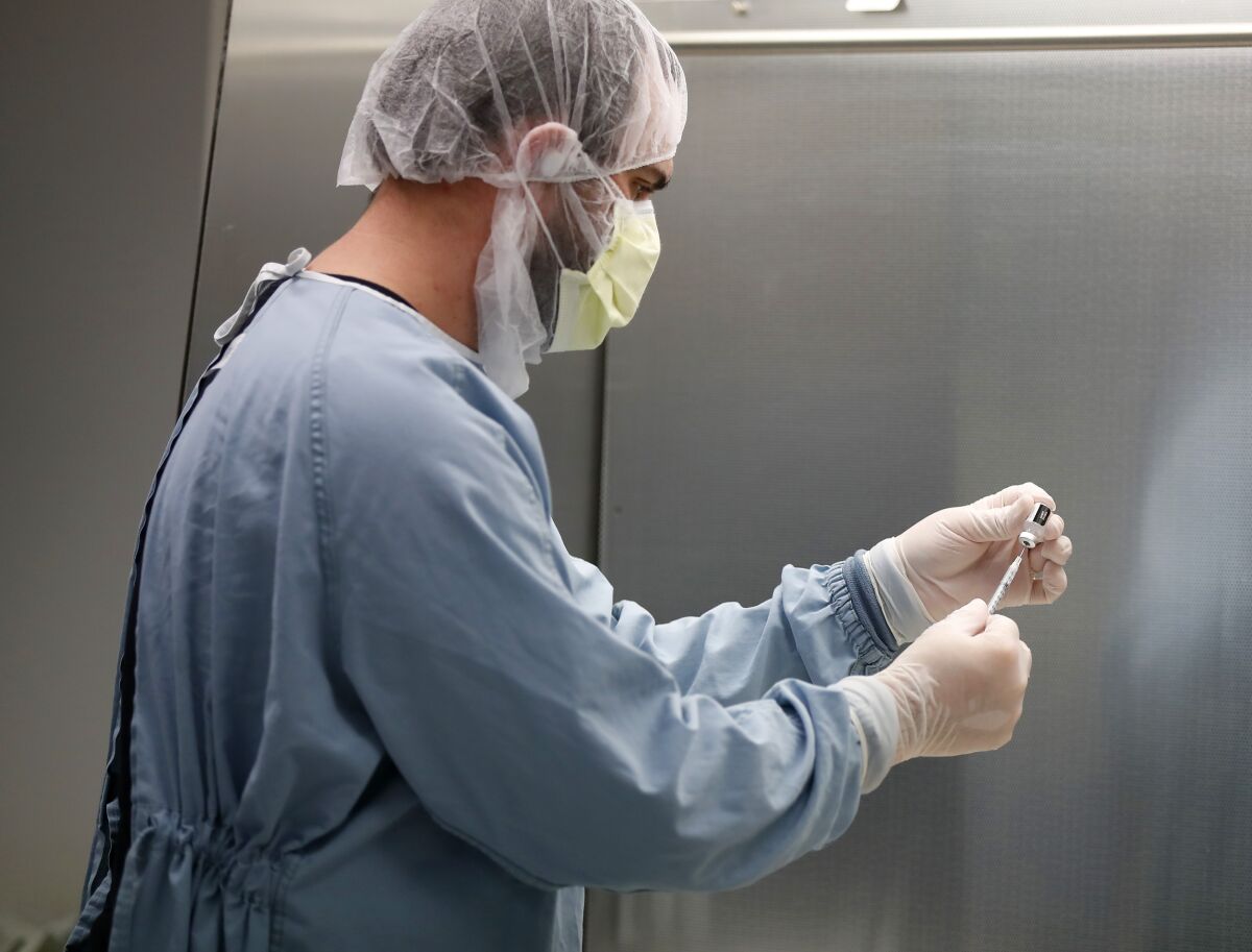 Pharmacy technician Kevin Ros prepares a coronavirus vaccine.