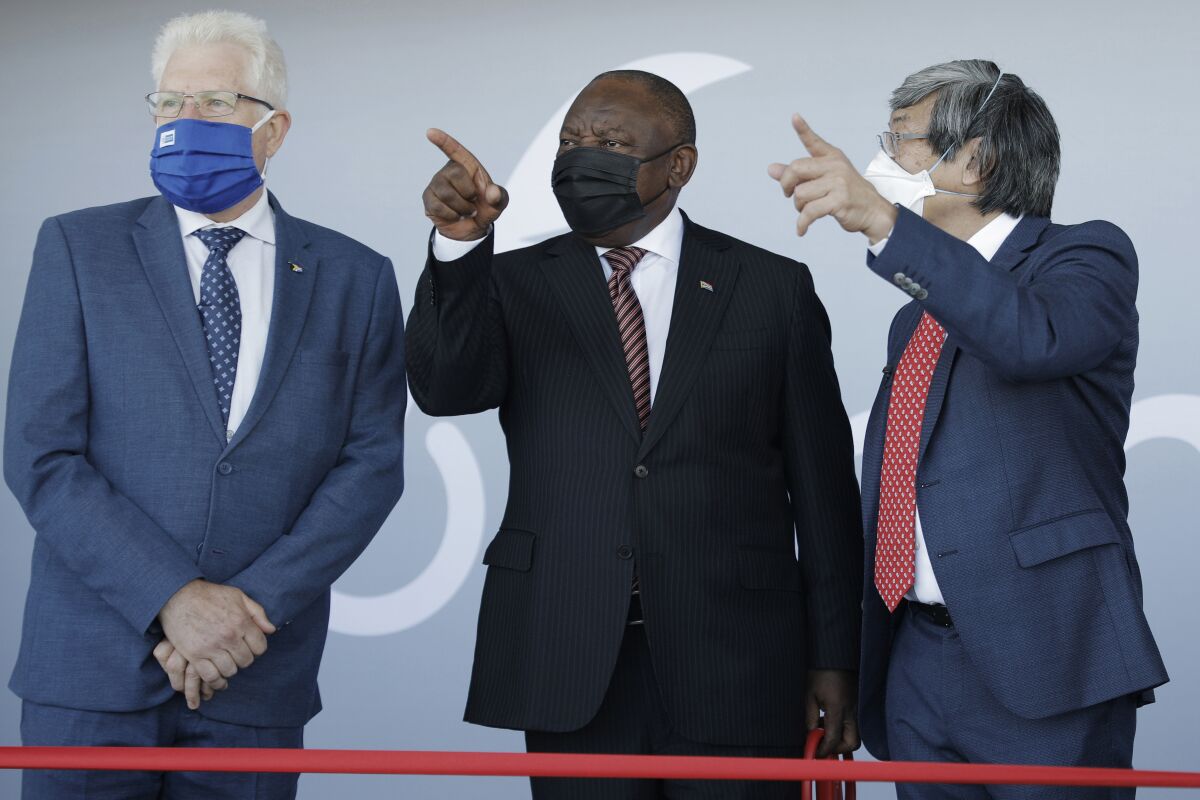 From left, Premier of the Western Cape Alan Winde, South African President Cyril Ramaphosa, and founder of NantWorks Dr Patrick Soon-Shiong gesture ahead of the ribbon cutting ceremony during the launch of NantSA, the future vaccine manufacturing campus in Brackengate, Cape Town, South Africa, Wednesday, Jan. 19, 2022. (Gianluigi Guercia /Pool Photo via AP)