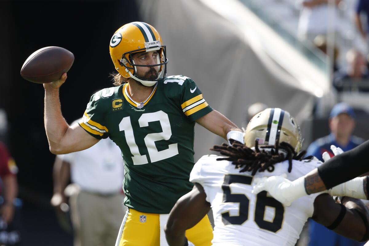 Green Bay Packers quarterback Aaron Rodgers (12) throws a pass as New Orleans Saints outside linebacker Demario Davis (56) rushes during the first half of an NFL football game, Sunday, Sept. 12, 2021, in Jacksonville, Fla. (AP Photo/Stephen B. Morton)