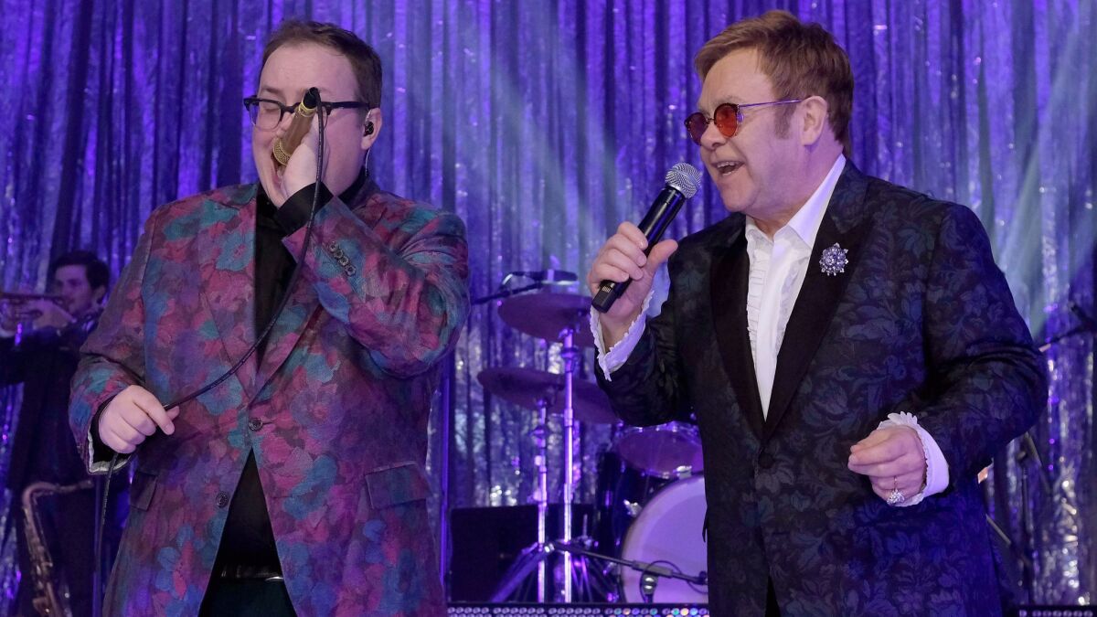 Singer Paul Janeway, left, of St. Paul & the Broken Bones and host Elton John duet during Sunday's 25th Academy Awards viewing party that raised $7 million for the Elton John AIDS Foundation.
