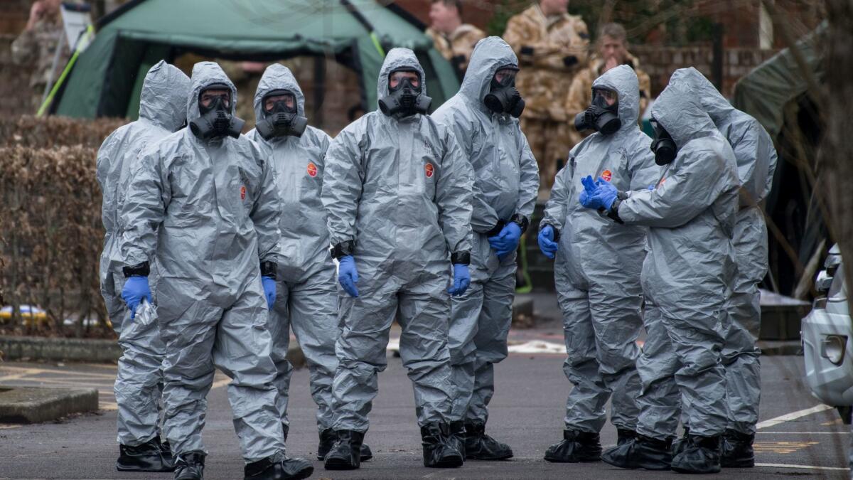 Military personnel wearing protective suits remove a police car and other vehicles from a public car park as they continue investigations into the poisoning of former Russian spy Sergei Skripa in Salisbury, England.