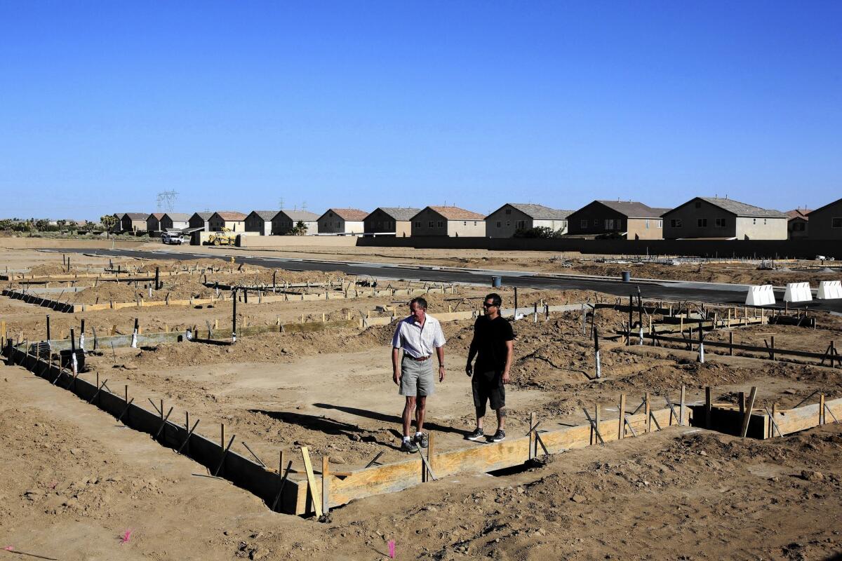 Michael Howarth, left, and Allen Colantuono of Sorrento Homes survey their company's new residential development project in Hesperia.