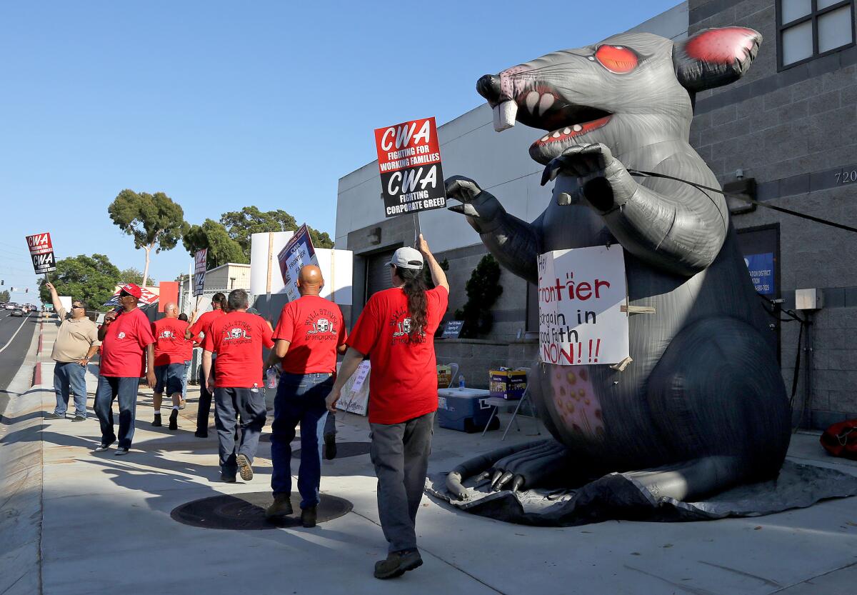 Communications Workers of America (CWA) employees picket outside the Huntington Beach Frontier office on Thursday.