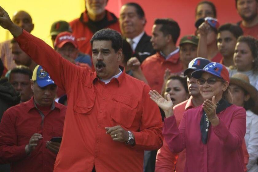 Venezuelan President Nicolas Maduro (L) and his wife Cilia Flores gesture during a May Day rally in Caracas on May 1, 2019. - Opposition supporters demonstrated for a second consecutive day in support of their country's self-proclaimed leader Juan Guaido as he bids to overthrow President Nicolas Maduro. Maduro and his government have vowed to put down what they see as an attempted coup by the US-backed opposition leader. (Photo by Juan BARRETO / AFP)JUAN BARRETO/AFP/Getty Images ** OUTS - ELSENT, FPG, CM - OUTS * NM, PH, VA if sourced by CT, LA or MoD **