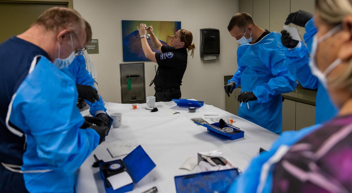 Lindsay Olsen instructs participants how to lift fingerprints during a session of the Costa Mesa Citizen's Police Academy.