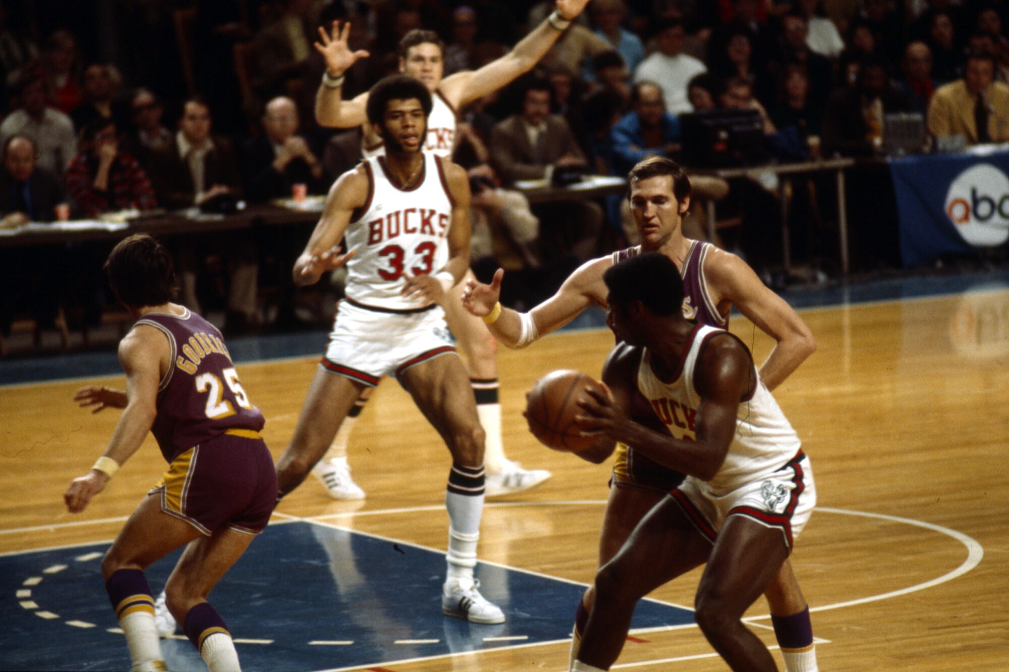 Bucks center Kareem Abdul-Jabbar looks to receive a pass from teammate Oscar Robertson, who is guarded by Jerry West.