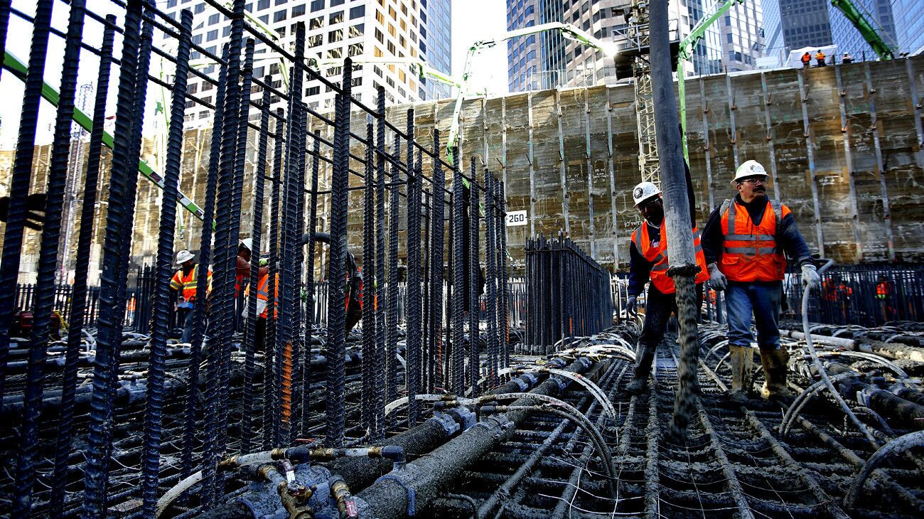 Workers direct concrete from a boom into the foundation of the New Wilshire Grand tower.