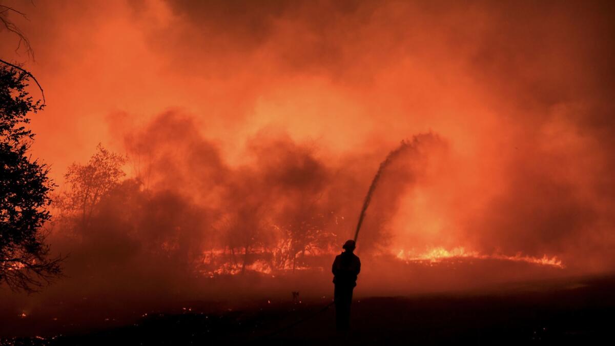 A firefighter battles the Thomas fire along Highway 33 in Casita Springs in Ventura County Tuesday.