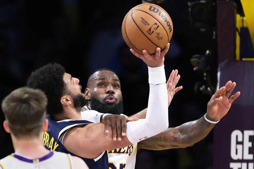LOS ANGELES, CALIFORNIA - APRIL 27: Lakers LeBron James prevents Nuggets Jamal Murray from making a shot in the first half in game 4 of the NBA playoffs at Crypto.com Arena Saturday. No foul was called on the play. (Wally Skalij/Los Angeles Times)