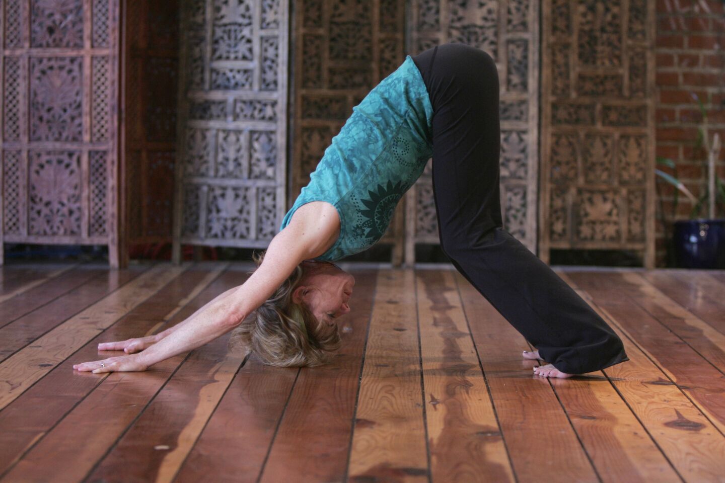 The body bends at the hips in an upside-down V, with arms straight, hands on the floor and heels pressing toward the floor. The head is aligned with the spine. Don't: Drop or hang into the shoulders. People do this in an attempt to truly stretch, but it prevents the joints from stacking properly and puts stress on the shoulders, elbows and wrists.