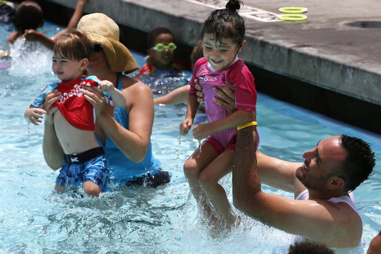 With Monday's midday temperature at 97 degrees, Paulette Davalos, 3, second from right, enjoys a refreshing dip with her dad, Francisco Davalos, during swim lessons at the Chaffey College Aquatics Center in Rancho Cucamonga.