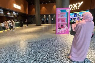 A woman in pink stands at the entrance of a movie theatre screening the film "Barbie", in Dubai on August 14, 2023. In nearby Kuwait, the hit film "Barbie" was barred from cinemas over concerns about "public ethics", while in Lebanon, the minister of culture asked the authorities last week to ban the movie for purportedly "promoting homosexuality". (Photo by Giuseppe CACACE / AFP) (Photo by GIUSEPPE CACACE/AFP via Getty Images)