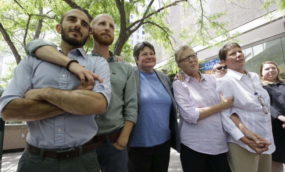 Moudi Sbeity, left, Derek Kitchen, Kate Call, Laurie Wood and Kody Partridge are five of the six people who brought the lawsuit against Utah's gay marriage ban. They are at a news conference in Salt Lake City.