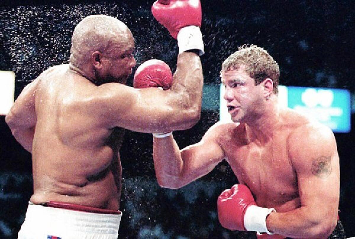George Foreman, left, and Tommy Morrison battle in the World Boxing Organization heavyweight title in June 1993, which Morrison won in 12 rounds.