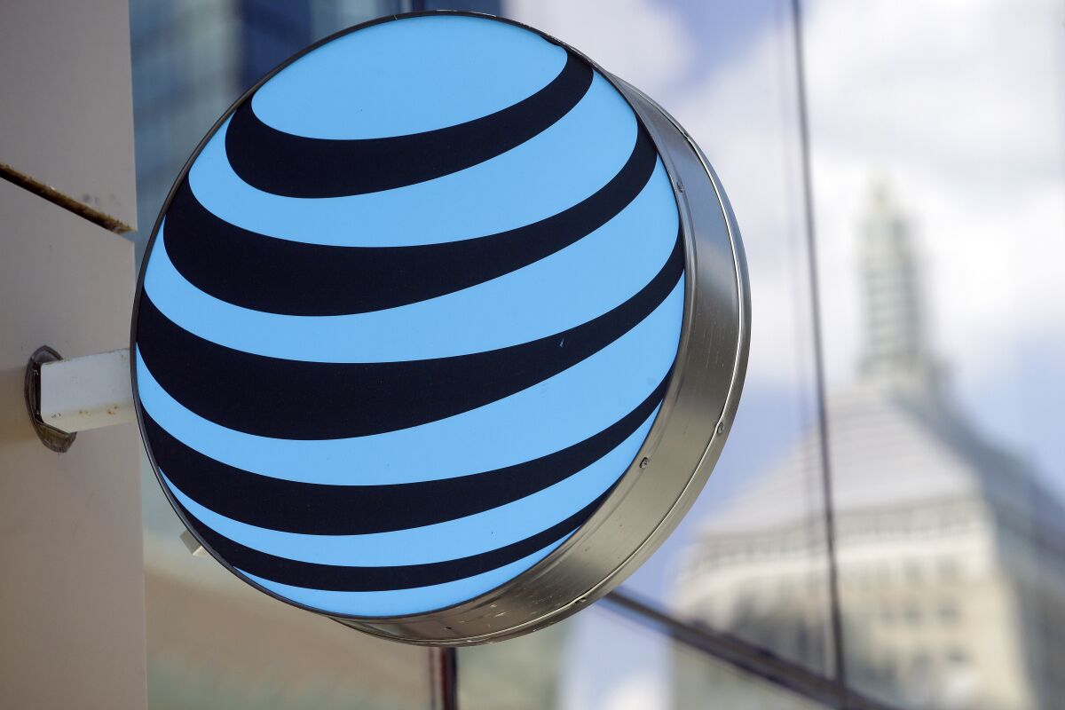 FILE - In this July 29, 2019 photo an AT&T logo sits above an entrance to a building, in Boston. U.S. antitrust regulators have cleared the $43 billion combination of Discovery and AT&T’s WarnerMedia, according to corporate securities filings, Wednesday, Feb. 9, 2022. Discovery says it and AT&T have not gotten objections from the Department of Justice or the Federal Trade Commission. (AP Photo/Steven Senne, File)