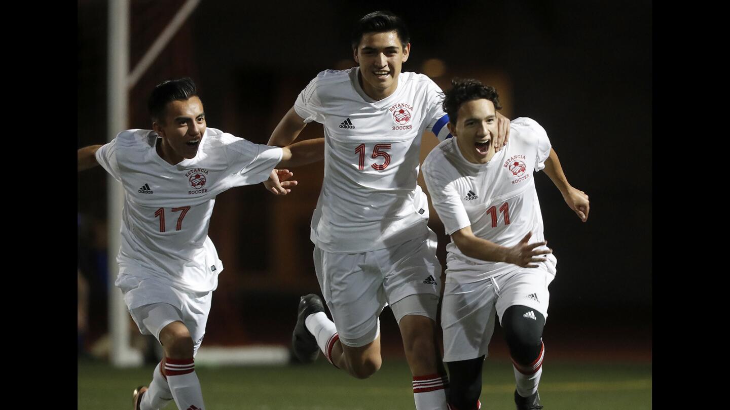 Estancia High's Andreas Millan (17) and Sergio Gutierrez (15) celebrate after teammate Nico Ramirez (11) gives the Eagles a 2-1 lead during the second half against Dana Hills in a CIF Southern Section Division 3 first-round playoff game on Friday in Costa Mesa.