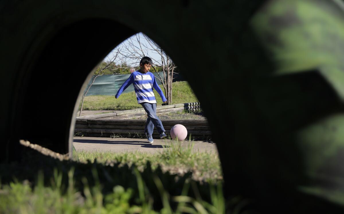 A boy kicks a ball. 