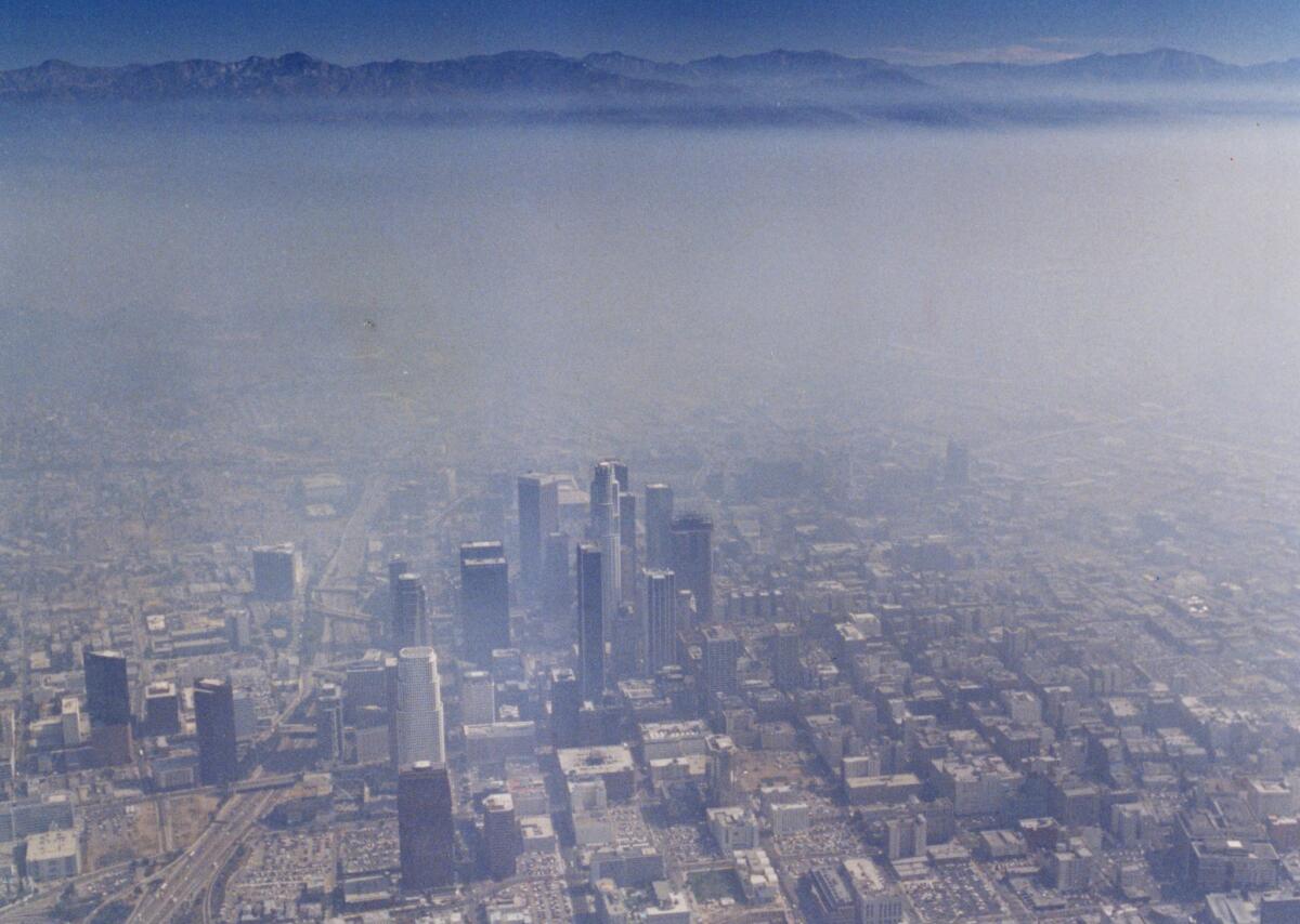 Aerial view of the downtown Los Angeles skyline covered in smog looking east toward the San Gabriel mountains in August 1990. (Robert Durell / Los Angeles Times)