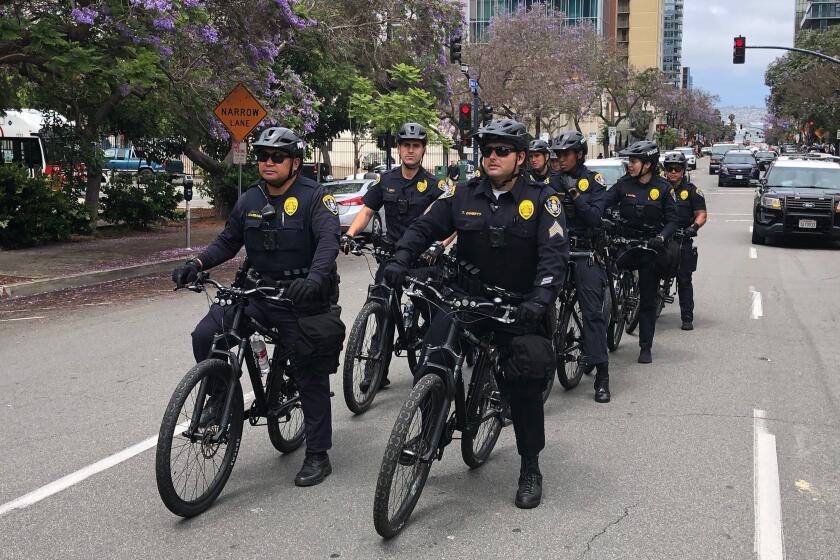 San Diego police quietly trail protesters at a distance on the streets of Saturday's march.