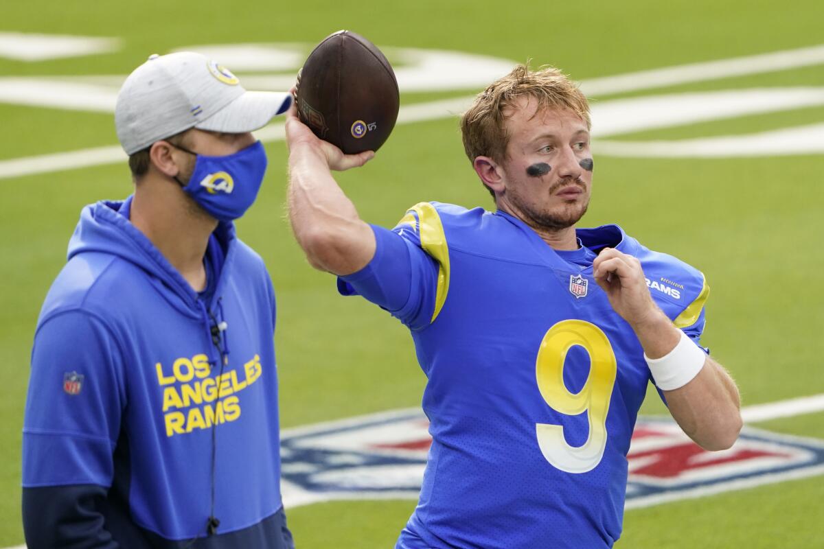 Injured Rams quarterback Jared Goff stands next to quarterback John Wolford before a game.