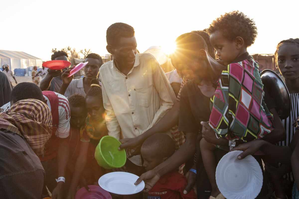 Refugees from the conflict in Ethiopia's Tigray region wait for food served by volunteers in eastern Sudan on Monday.