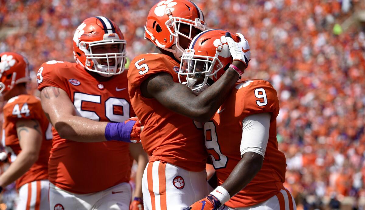 Clemson's Travis Etienne (9) celebrates his touchdown with Tee Higgins (5) and Gage Cervenka during the second half Saturday.