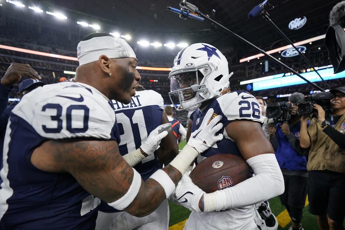 Cowboys cornerback DaRon Bland, right, celebrates with safety Juanyeh Thomas after returning an interception for a score.