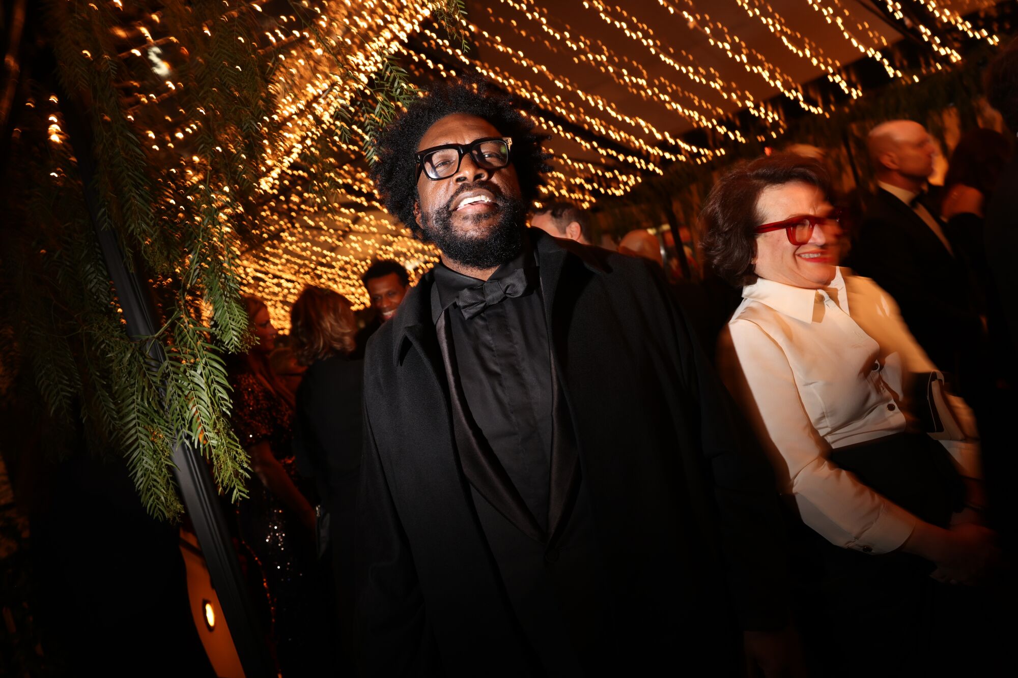Questlove grins beneath strings of white lights.