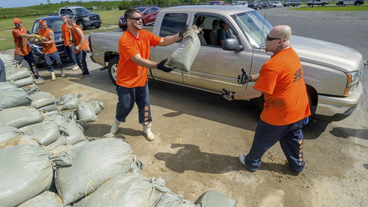 St. Bernard Parish jail inmates help residents load sandbags in Chalmette, La., on Thursday, ahead of the arrival of Tropical Storm Barry.