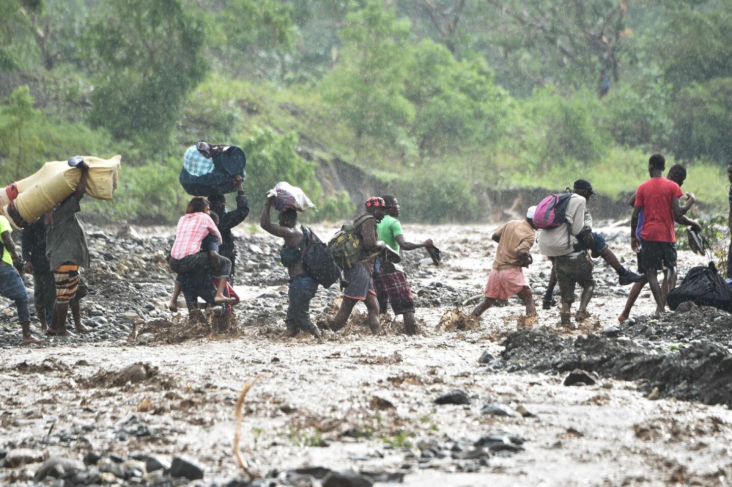Haitian people cross the river La Digue in Petit Goave, southwest of Port-au-Prince, after Hurricane Matthew.