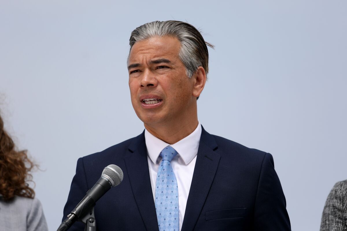 A man in a suit and tie speaks at a microphone