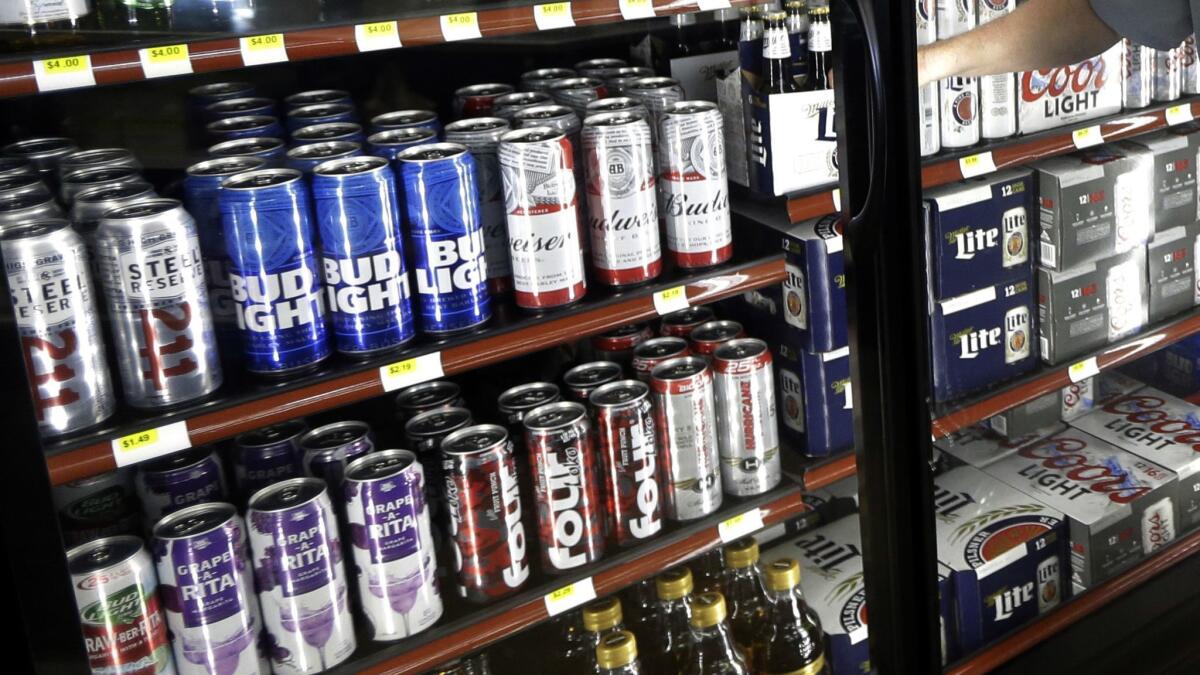 Beer in aluminum cans fills a refrigerated case at a convenience store in Indiana.
