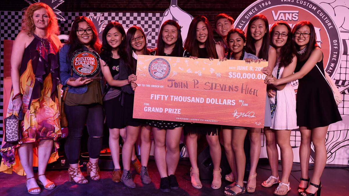The team from John P. Stevens High School hoists its oversized grand-prize check at the June 8 event in downtown L.A.