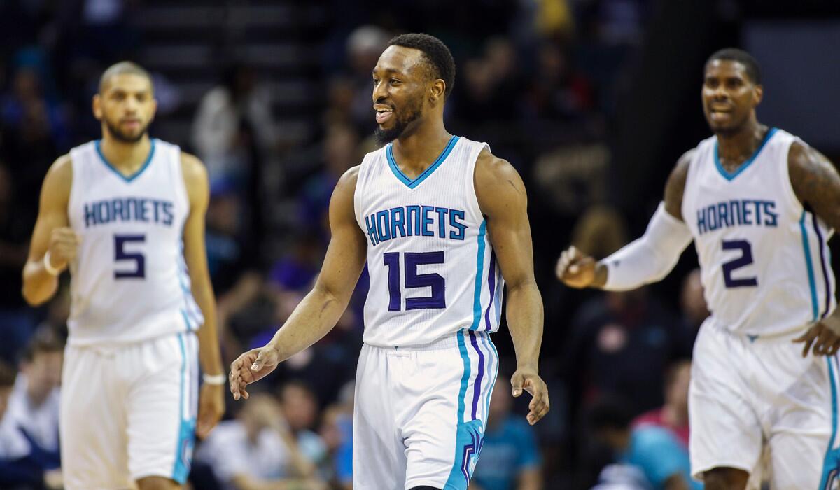 Charlotte Hornets guard Kemba Walker, center, smiles as teammates Nicolas Batum, left and Marvin Williams look on after Walker hit a 3-pointer in the closing seconds against the New Orleans Pelicans in the second half on Wednesday.