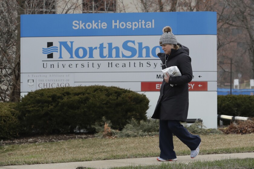 A woman walks in front of NorthShore Skokie Hospital in Illinois on Friday.