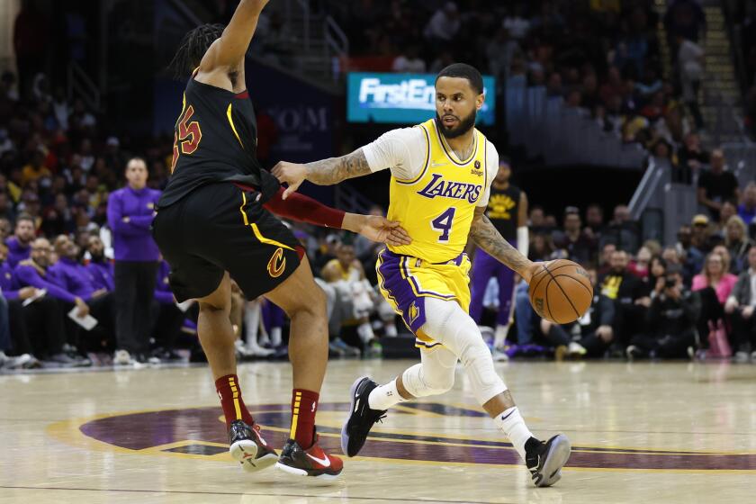 Los Angeles Lakers' D.J. Augustin (4) drives against Cleveland Cavaliers' Isaac Okoro, left, during the second half of an NBA basketball game, Monday, March 21, 2022, in Cleveland. (AP Photo/Ron Schwane)