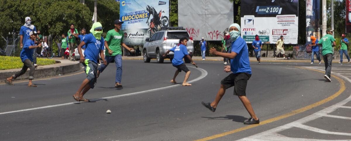 Foto para ilustrar. Un grupo de personas ataca con piedras a manifestantes en Managua el miércoles 11 de noviembre del 2015.